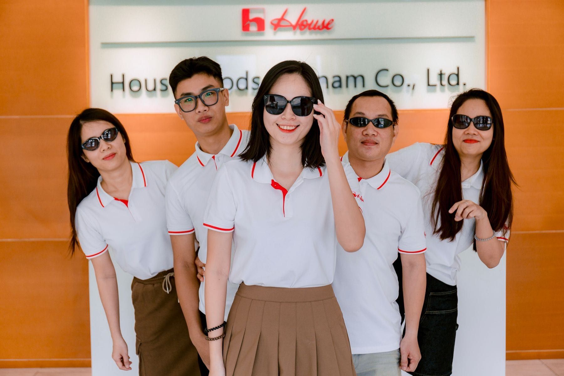 Office staff in matching navy shirts and grey trousers standing together