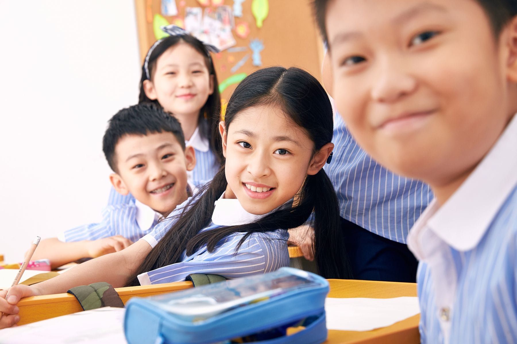 Children's school polo shirts and grey trousers folded on a table