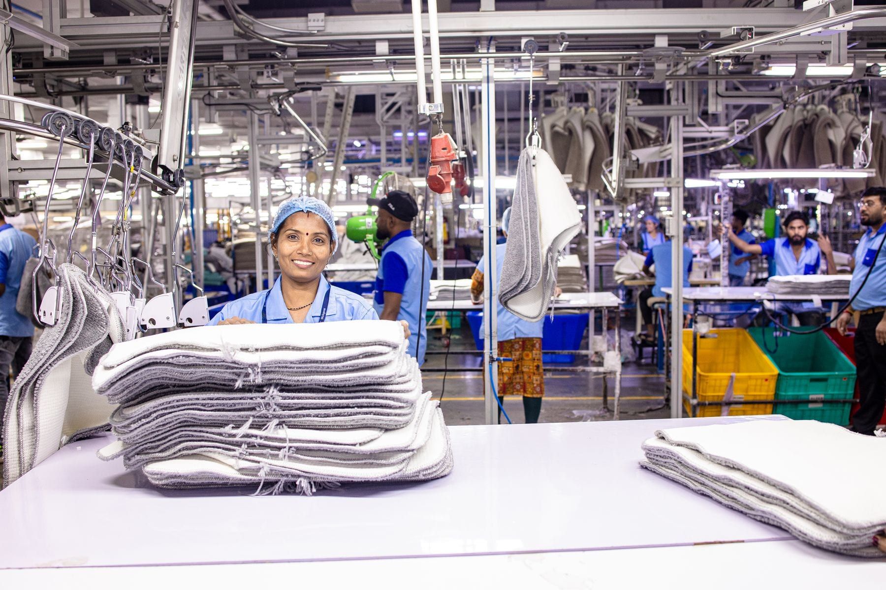 Worker checking a finished shirt against a specification