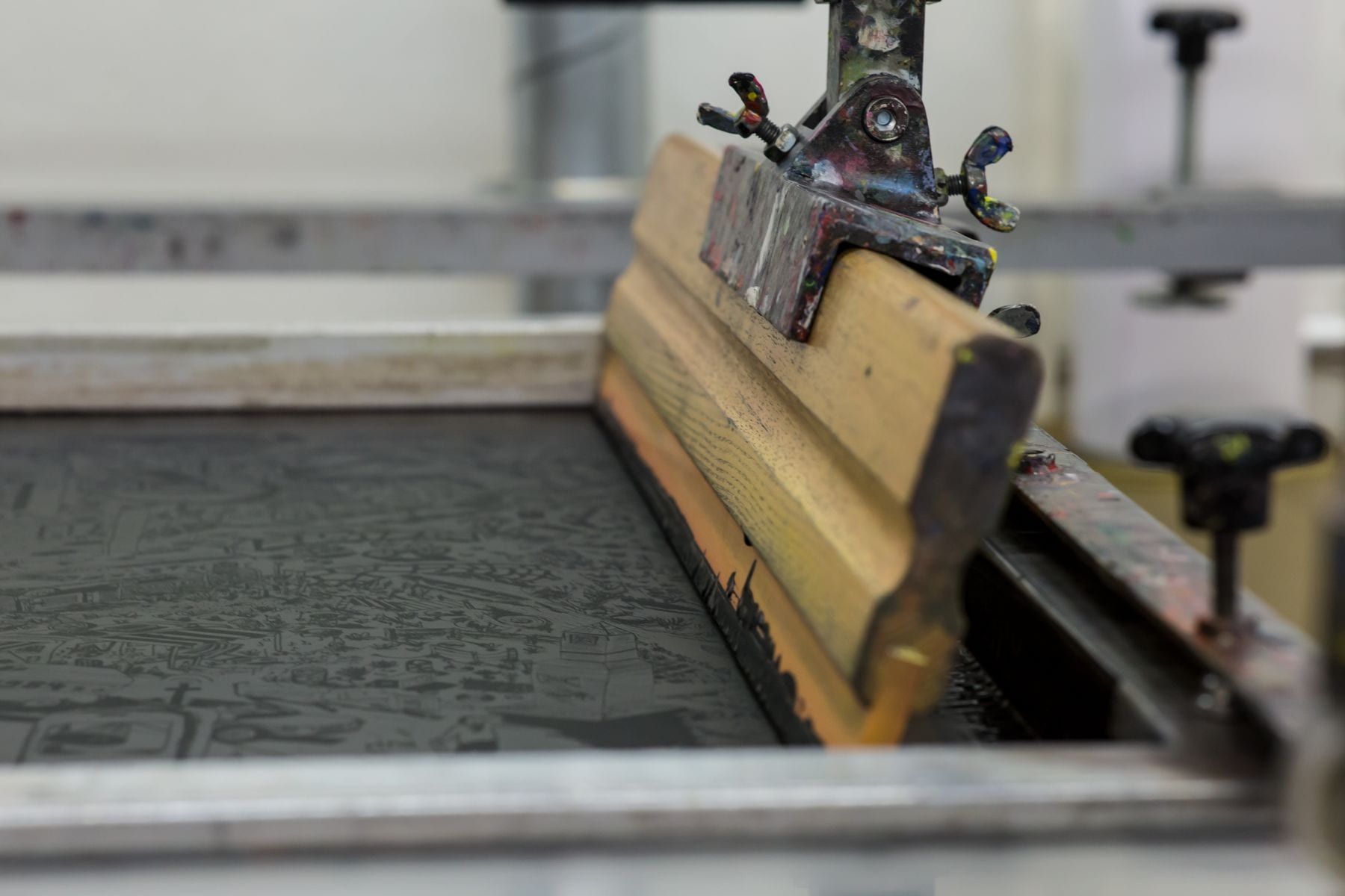 Embroidery machine stitching a logo onto a navy polo shirt chest