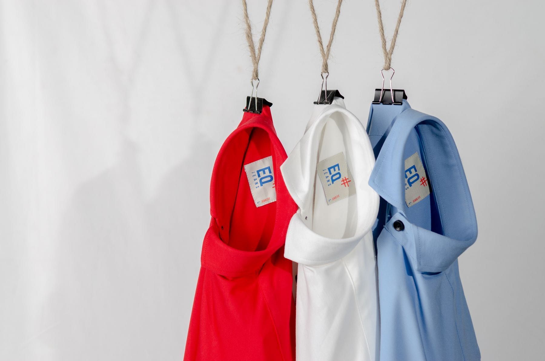 Folded navy shirts with a woven brand label at the neck