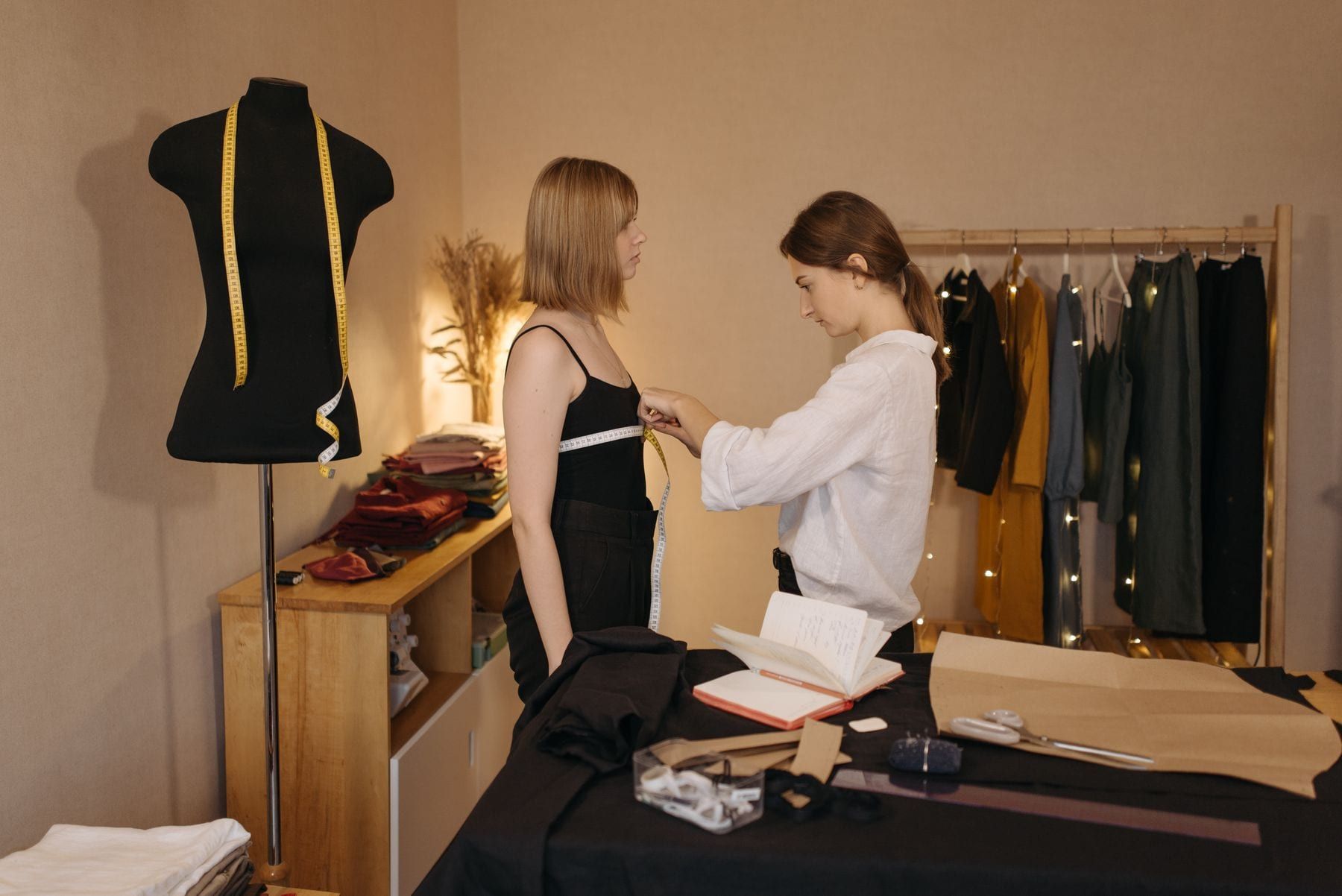 Sample shirt on a dress form beside a measurement sheet
